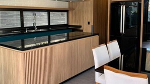 Una cocina moderna con una isla central, electrodomésticos negros y armarios de madera.