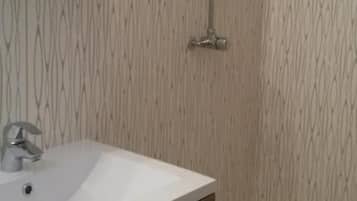 Een douche, handdoeken, zeep, shampoo