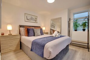 Relax in a cozy space with a made bed, nightstand, and large mirror.