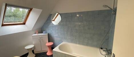 A bathroom with a bathtub, a sink, a toilet, and a vanity.