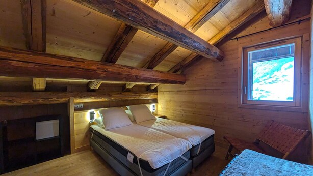 A wooden cabin room with a bed, a window, and a table. - Cozy alpine lodge, 4 bedrooms, 10 guests, parking, terrace, Arêches-Beaufort (Arêches-Beaufort)