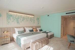 A bedroom with a large bed, bedside tables, a bench, and a chair.