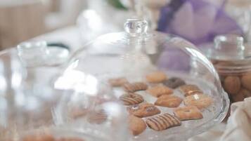 A buffet table with various food items covered in glass domes.