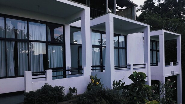 A modern multi-story building with large windows and balconies. - Monarch Ella (Ella)