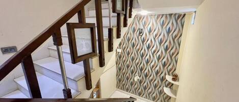 A staircase with wooden railings and patterned wall tiles.