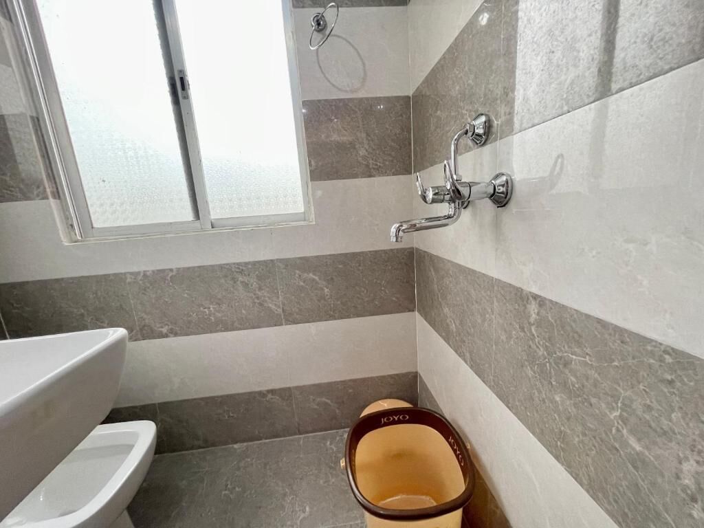 A bathroom with a toilet, a bidet, and a shower area with a glass door.