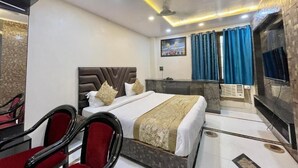 Ein Hotelzimmer mit Bett, Schreibtisch, Stuhl, Fernseher und Bad.