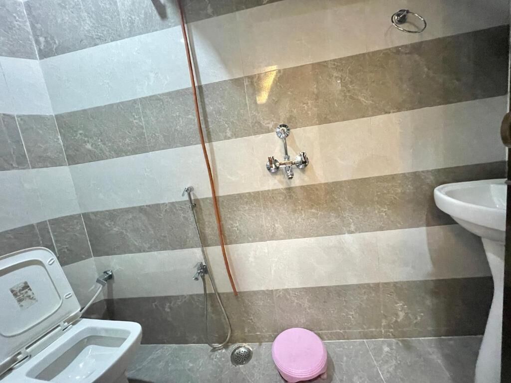 A bathroom with a shower, toilet, and sink.