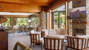 A spacious indoor area with wooden ceiling and stone walls, featuring a sofa, chairs, and a fireplace. - Regnum Banya Thermal Hotel (Razlog)
