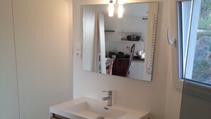 A modern bathroom with a built-in sink, a mirror, and a window.