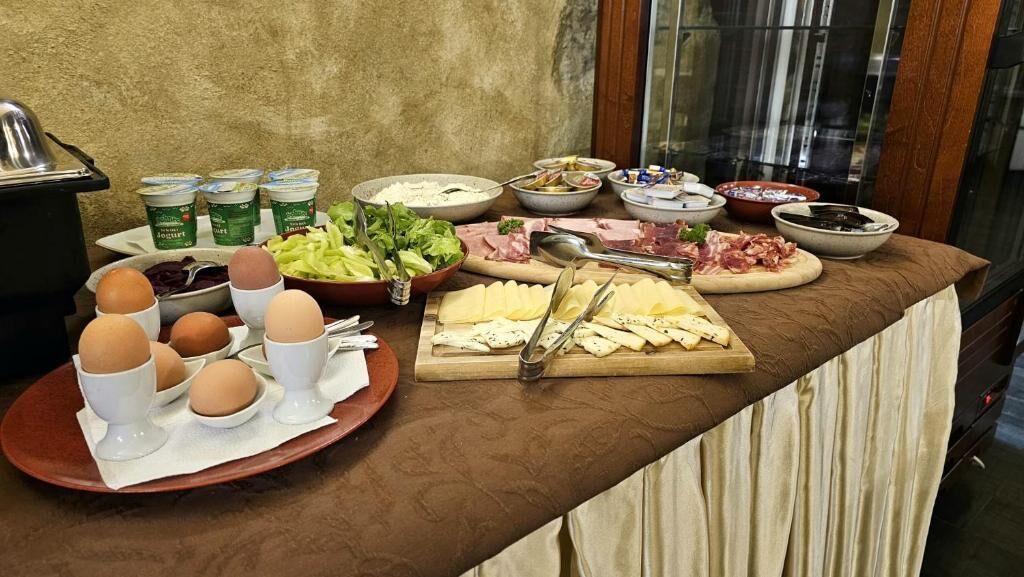 A buffet table with various food items including eggs, cheese, meats, and salads.
