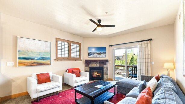 A living room with a fireplace, two sofas, a coffee table, and a ceiling fan. - Luxury Townhome, Private Balcony, Great Location, 3 Bedrooms, Hot Tub! (Park City)