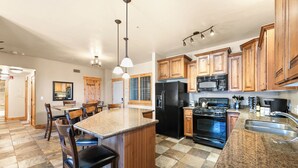 A kitchen with granite countertops, wooden cabinets, a black refrigerator, a stove, and a sink. - Luxury Townhome, Private Balcony, Great Location, 3 Bedrooms, Hot Tub! (Park City)