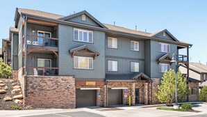 A multi-story building with a brick facade, balconies, and a garage entrance. - Luxury Townhome, Private Balcony, Great Location, 3 Bedrooms, Hot Tub! (Park City)