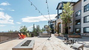 Eine Terrassenanlage im Freien mit Sitzgelegenheiten, einem Grill und Lichterketten.