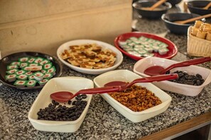 Un bufé con diversas opciones de comida y utensilios para servir.