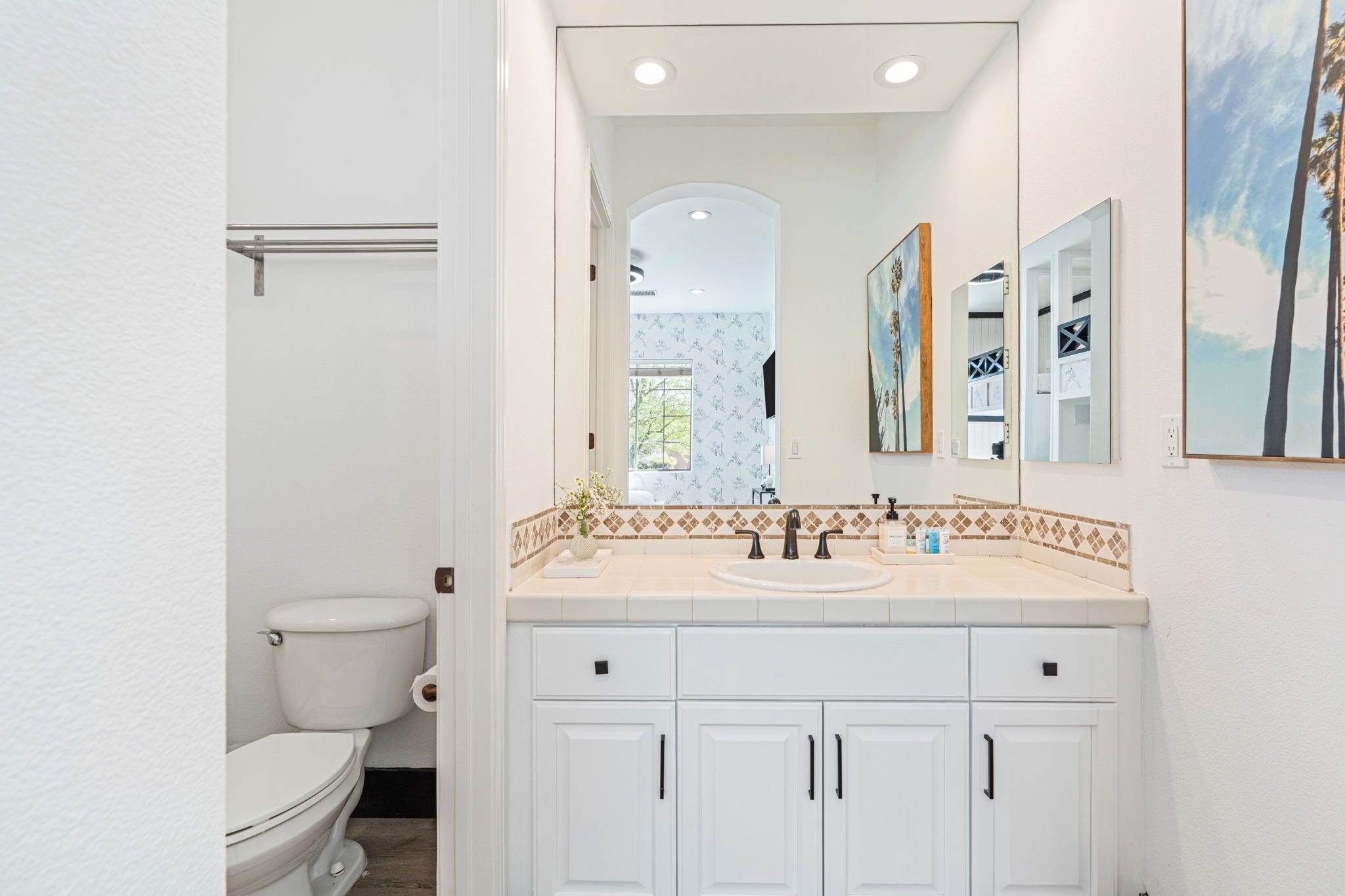 A bathroom with a toilet, a sink, and cabinets.