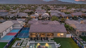 A residential area with houses, a swimming pool, and a tennis court. - All inclusive - Spider-Man Retreat: Waterslide, 100K Gameroom, Pickleball, Bocceball & More! (Indio)