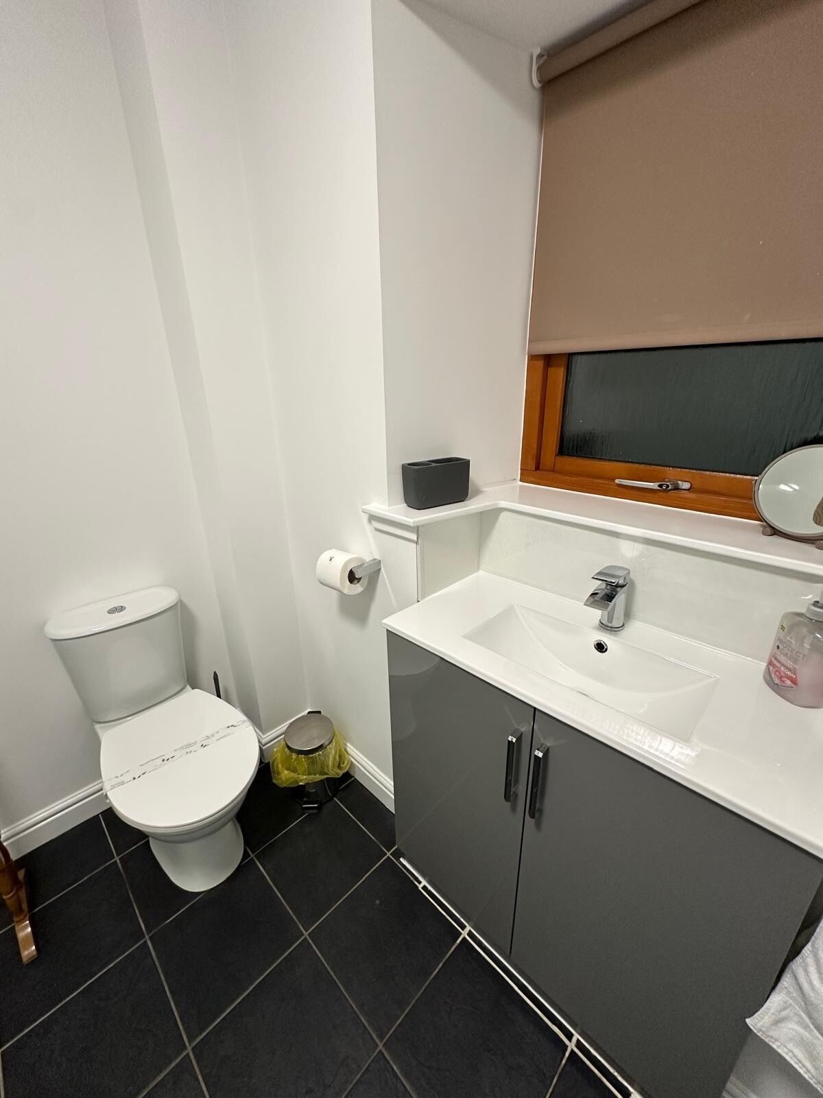 Un bagno con il water, un lavandino e uno specchio.