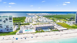 Un complejo turístico frente al mar, con playa, piscina y puerto deportivo.