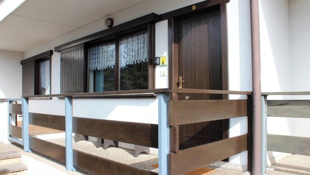 A building with a wooden balcony and a door marked with the number 4. - Suite Marco Nice Apartment in Cavalese With View (Cavalese)