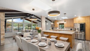 A modern kitchen with a central island, wooden cabinets, and a large refrigerator. - Red Rocks House | Chef`s Kitchen, Fireplace (Sedona)