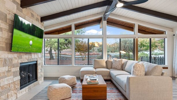 A spacious living room with a fireplace, large windows, and a comfortable seating area. - Red Rocks House | Chef`s Kitchen, Fireplace (Sedona)