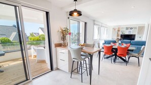 Een moderne keuken met een eethoek, grote ramen en een balkon.