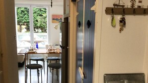 En hall med en matplats, ett blått skåp och en hylla med nycklar.