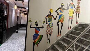 Una escalera con barandilla y una pared decorada con arte de colores.