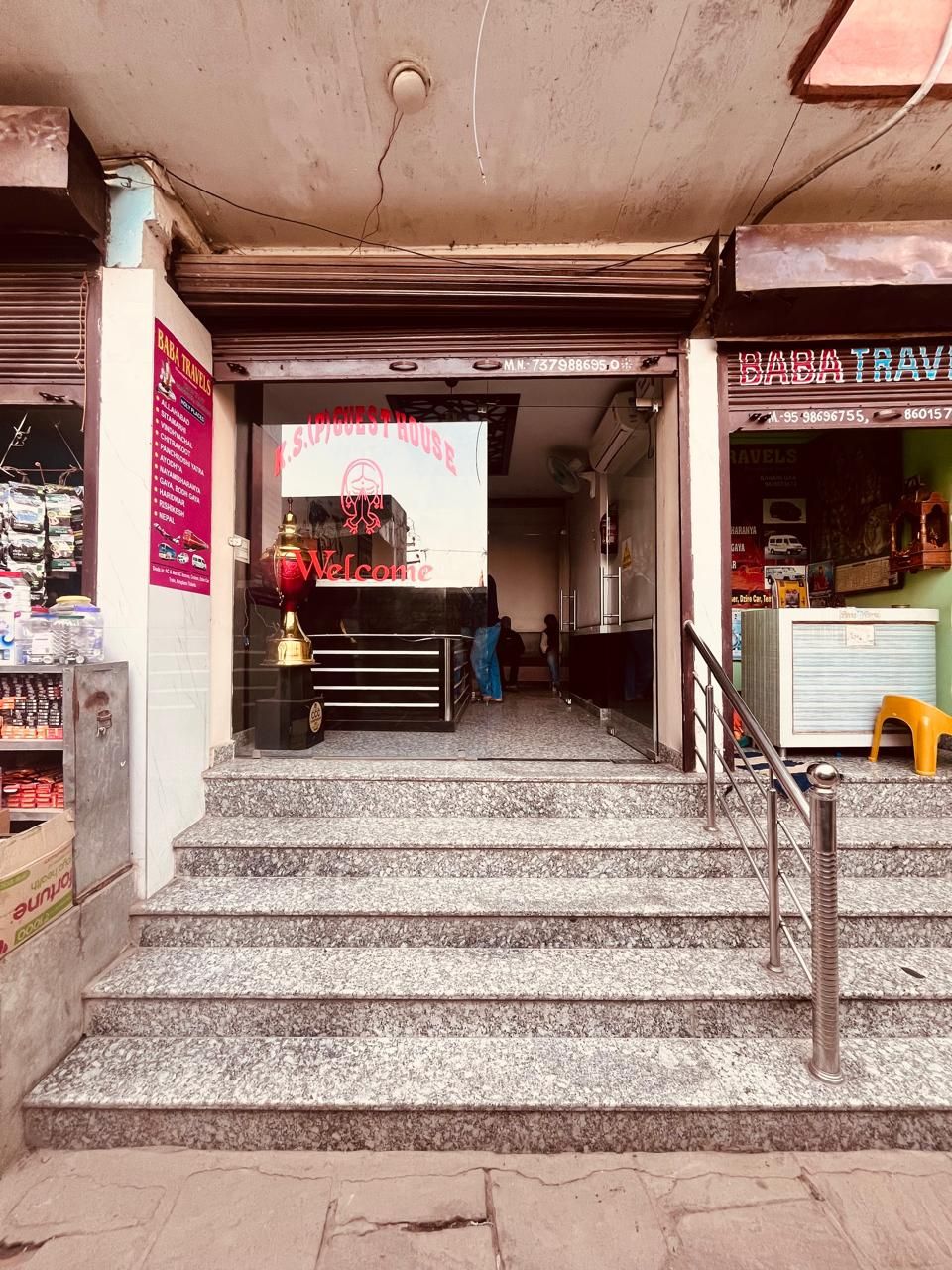 A staircase leading to a shop with a neon sign reading "Welcome".