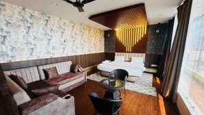 Una habitación de hotel moderna con sofá, una mesa redonda y una cama.