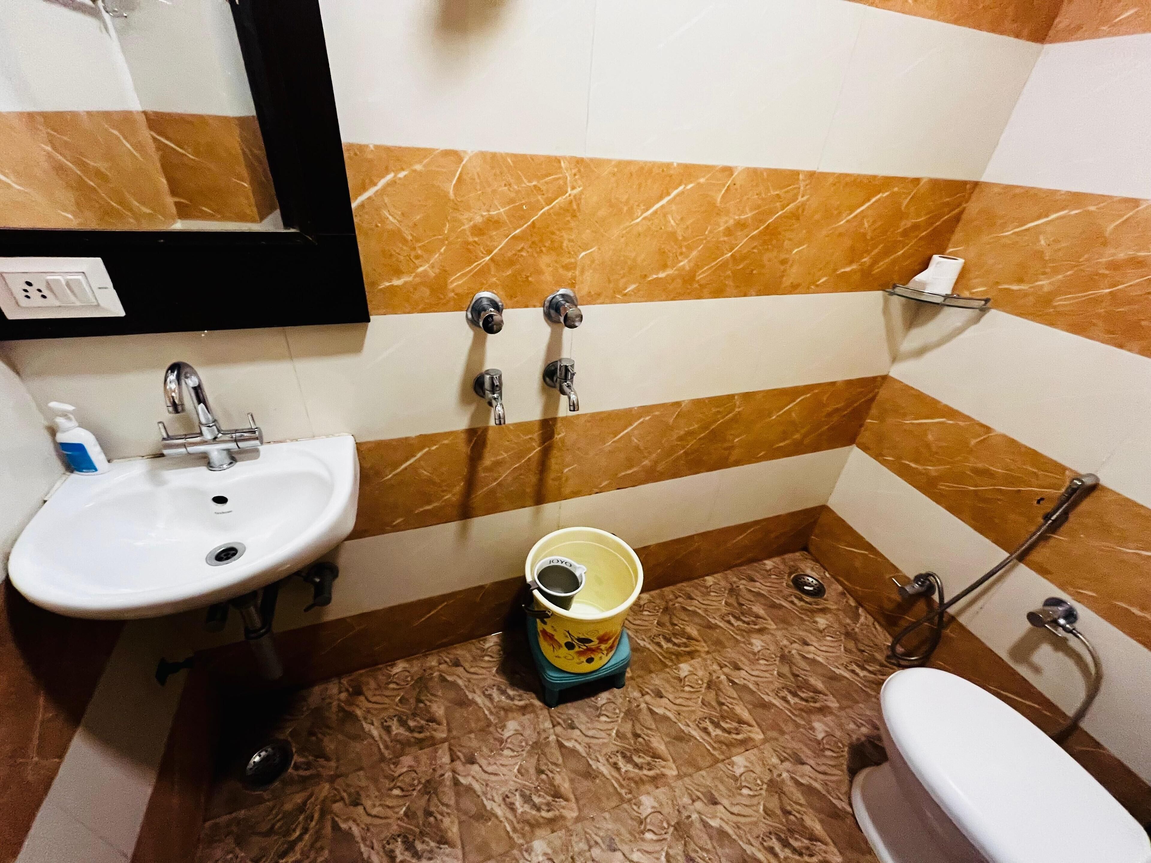 Une salle de bain équipée d’un lavabo, d’un miroir, de toilettes et d’une douche.