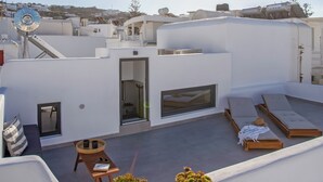 A rooftop terrace with a clear view of the sky, a small seating area, and a potted plant. - The pelican heritage house, Rooftop Chora Mykonos center (mykonos)