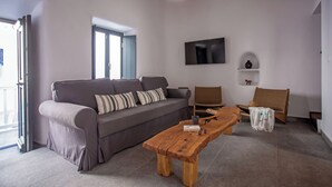 A modern living room with a grey sofa, a wooden coffee table, and a wicker chair. - The pelican heritage house, Rooftop Chora Mykonos center (mykonos)