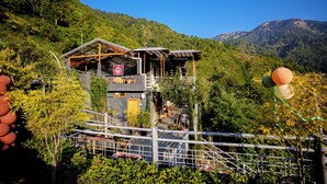 A mountain lodge with a wooden structure, a balcony, and a view of the surrounding forest. - Valtara Resort (Nainital)