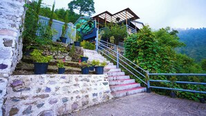 A stone staircase leading to a wooden structure with a metal railing. - Valtara Resort (Nainital)