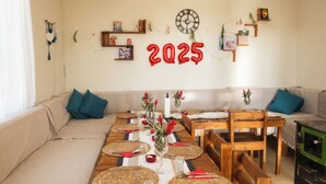 Una sala acogedora con un sofá, una mesa de comedor para cuatro personas y un mueble de televisión verde.
