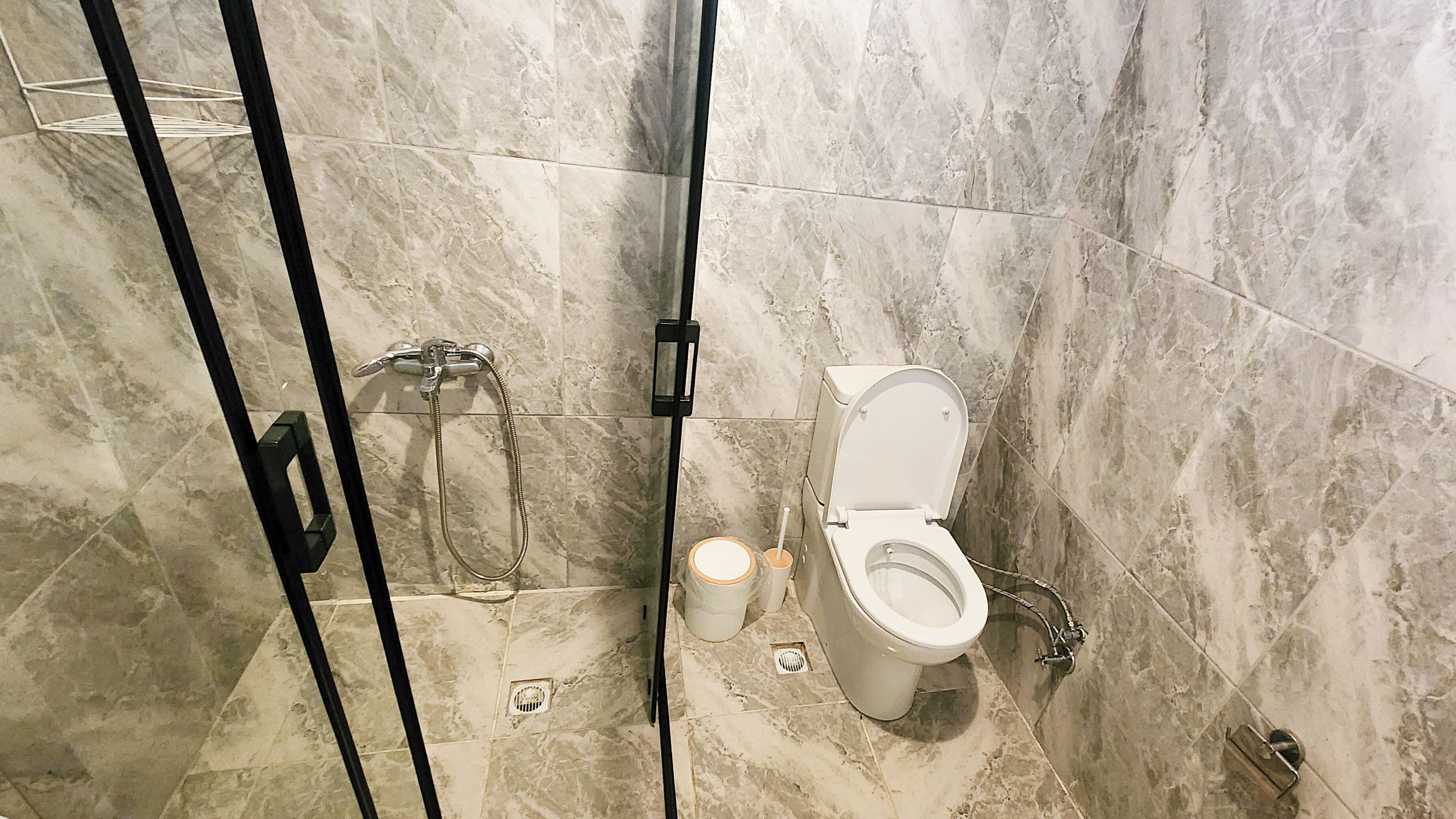 Un baño con inodoro, ducha e inodoro de lavado.