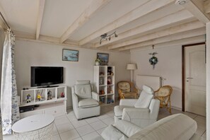 Relax in a stylish living room with a flat-screen TV, comfortable seating area, and a small table.