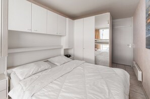 A bedroom with a bed, a nightstand, and a wardrobe. - 1 bedroom accommodation in Blankenberge (Blankenberge)