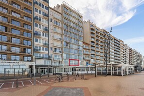 Ein mehrstöckiges Hotel mit modernem Design, das eine auffällige Eingangspartei mit Glasfassade und einen überdachten Außenbereich zum Verweilen bietet.