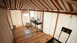 A tent with a wooden floor, a toilet, a sink, and a small window. - Van Bagh Camp Village (Alwar)