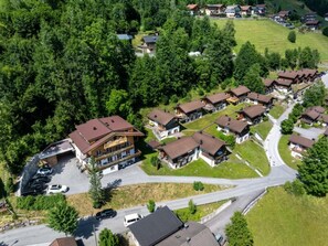 A residential area with multiple houses, a parking lot, and a road.