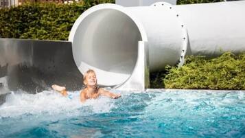 Eine Rutsche mit einer Person, die in ein Schwimmbecken gleitet.