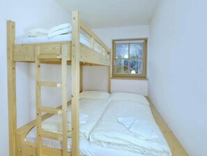 A bunk bed with a window in a room.