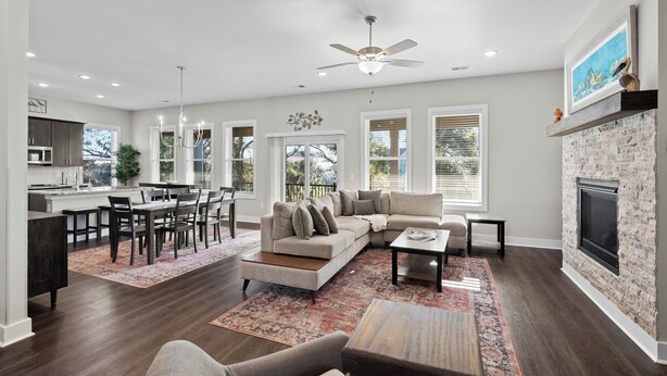 A spacious living room with a fireplace, a dining area, and a kitchen.