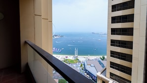 A high-rise building with a view of a coastal area, including a beach and a tall structure in the distance. - YouSleep Hostel (Dubai)