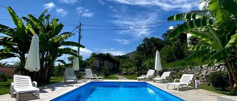 Kauden mukainen ulkouima-allas, aurinkovarjoja