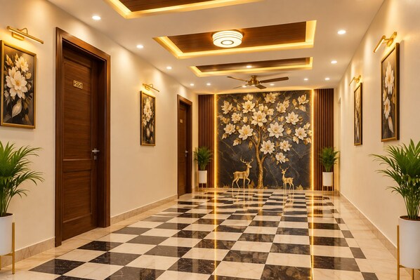 A hotel lobby with a checkered floor, wooden doors, and wall-mounted artwork. - The Bed and Rock (New Delhi)